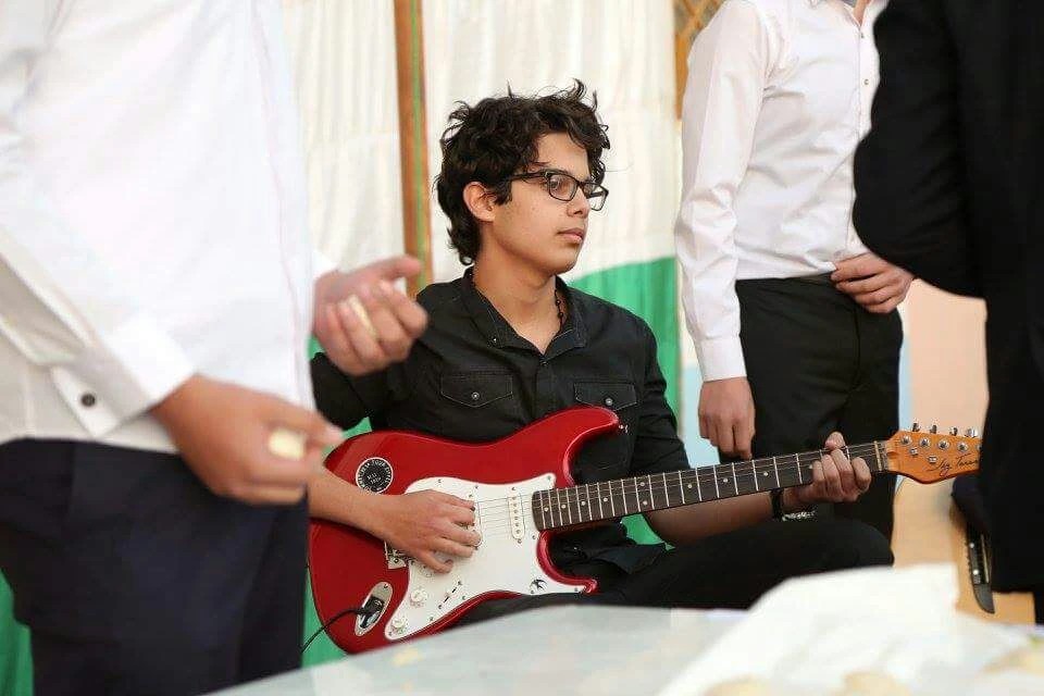 Nizar Masadeh playing guitar at Levant School